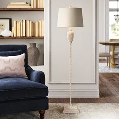 a living room with a blue chair and a lamp on the floor next to it