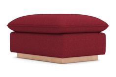 a red ottoman that is sitting on top of a wooden base and has a cushion