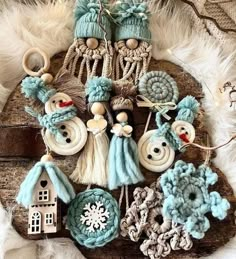 some crocheted ornaments are hanging on a piece of wood with feathers around them