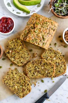 several slices of bread sitting on top of a cutting board next to bowls of food