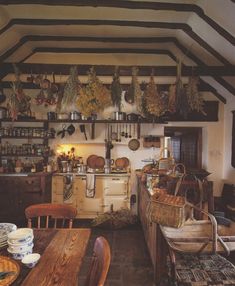 an old fashioned kitchen with wooden floors and exposed ceilings, filled with pots and pans