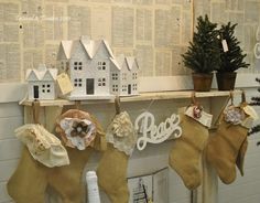 stockings hanging from a shelf with christmas decorations on them and small houses in the background