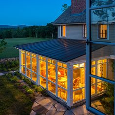 a house that is lit up at night with the lights on and windows showing outside