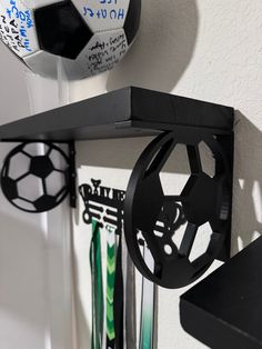 a soccer ball hanging from the side of a wall next to other sports items on a shelf