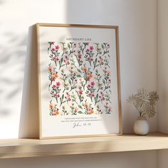 an arrangement of flowers is displayed on a shelf next to a potted plant and vase