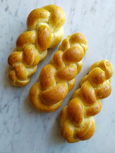 three braided breads sitting on top of a white counter