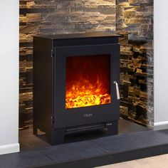 a fireplace with a fire burning in it's side and rocks on the wall behind it