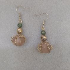 Frosted, translucent baroque soft pumpkin orange beads caged with gold wire tendrils. They fall below an intricately molded gold bead that is topped by a small green glass bead that catches light with its subtle sparkly swirls.  I think they would be perfect for an enchanted evening in October! Bronze Wire Wrapped Drop Earrings, Bohemian Orange Wire Wrapped Jewelry, Gold Aventurine Beaded Jewelry, Handmade Peach Dangle Jewelry, Unique Gold Wire Jewelry, Gold Bohemian Wire Jewelry, Bohemian Gold Wire Jewelry, Wire Wrapped Copper Beaded Dangle Earrings, Bohemian Amber Wire-wrapped Earrings