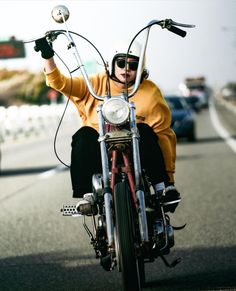 a man riding on the back of a motorcycle down a street