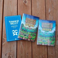 three children's books sitting on top of a wooden table next to each other