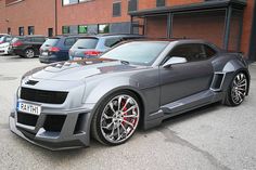 a gray sports car parked in front of a building