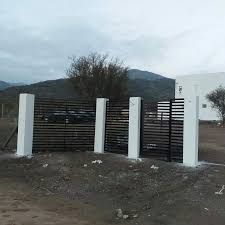 a gated in area with trees and mountains in the background