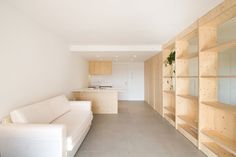 a white couch sitting in a living room next to a book shelf