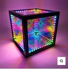 an illuminated cube with different colored lights on the sides and bottom, in front of a purple background