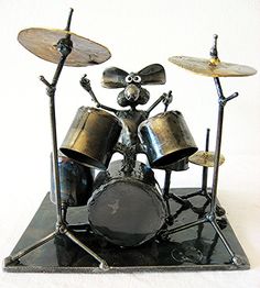 a statue of a mouse playing drums on top of a black base with two sticks