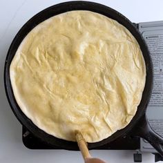 a skillet that has some food in it on the stove top with a spatula next to it