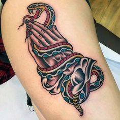 a woman's thigh with a tattoo design on it and a snake wrapped around the leg