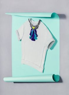 a white t - shirt hanging on a blue wall