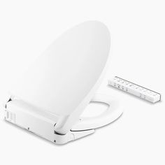 an image of a white toilet seat with the lid up and two remotes nearby