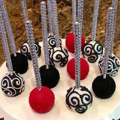 there are many different types of cake pops on the plate with red and black decorations