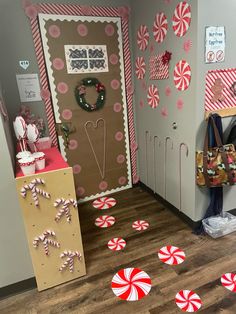 candy canes on the floor in front of a door decorated with christmas wreaths