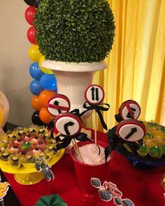 a table topped with lots of food and desserts next to a potted plant