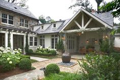 a large house with lots of windows and plants in the front yard, surrounded by greenery