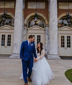 a bride and groom standing in front of an old building with columns on either side