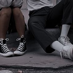 two people sitting on the ground with their legs crossed