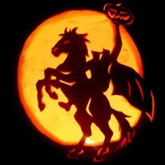 a carved pumpkin with a silhouette of a horse and rider in front of a full moon