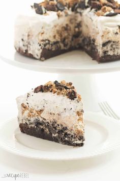 two slices of oreo cookie ice cream cake on white plates with one slice missing