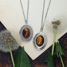 Semi-precious stone on a vintage brass, antiqued silver, or shiny silver oval locket, perfect for remembering your loved ones. On a 28 inch chain. Choose from: Goldstone, Leopardskin Jasper, Tigereye or Carnelian. I can change the chain to any length, just leave a note at checkout. Oval Metal Locket Necklace, Oval Amber Jewelry, Spiritual Bronze Oval Jewelry, Spiritual Oval Bronze Jewelry, Vintage Oval Pendant Jewelry With Natural Stones, Vintage Jewelry With Oval Pendant And Natural Stones, Brass Cabochon Oval Pendant Jewelry, Bohemian Jewelry With Oval Pendant Locket, Bohemian Oval Pendant Locket Jewelry