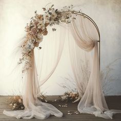 a wedding arch decorated with flowers and feathers