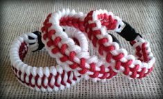 two red and white baseball bracelets sitting on top of a table