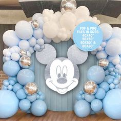 a mickey mouse balloon arch with silver and blue balloons on it's sides for a birthday party