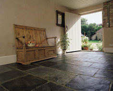 a wooden bench sitting on top of a stone floor