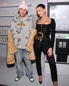 two people standing next to each other in front of a vending machine