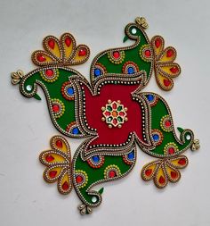 an intricately designed piece of art on a white surface with green, red and yellow colors