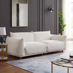 a white couch sitting in a living room next to a table