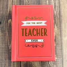 a red book with the words for the best teacher ever on it sitting on top of a wooden table