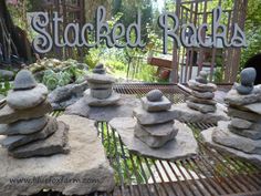 stacks of rocks sitting on top of a metal table in front of a sign that says stacked rocks