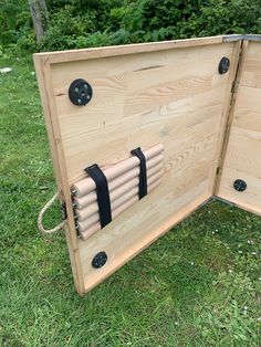 the back side of a wooden structure with black straps on it and two holes in the middle