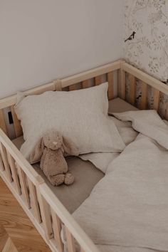 a stuffed animal sitting on top of a bed next to pillows