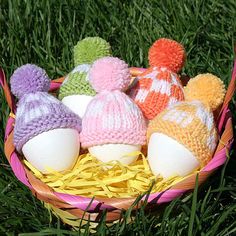 several knitted eggs in a basket on the grass