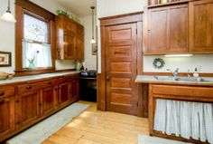 a kitchen with wooden cabinets and white walls