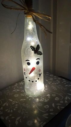 a lighted bottle with a snowman face on it