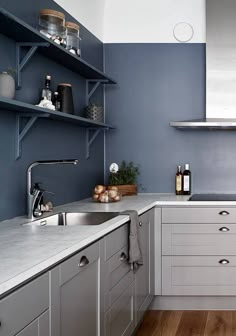 a kitchen with blue walls and white cabinets