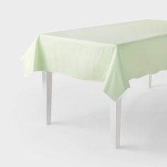 a green table cloth on top of a white wooden table with two legs and one leg