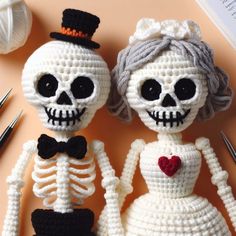 two crocheted skeletons are sitting next to each other