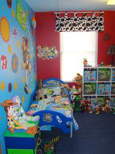 a child's bedroom decorated in blue, red and green with toy animals on the wall